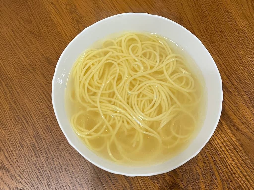 調理後のオリーブラーメン。澄んだ塩スープに手延べ麺が浮かぶ一杯